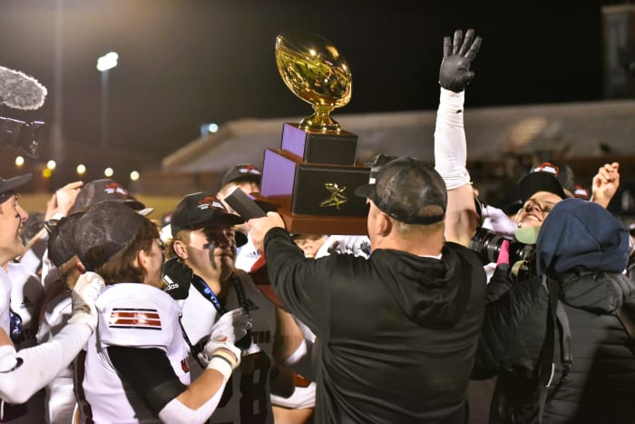 Washington players celebrate after being awarded the Class 2A state championship trophy on Dec. 9, 2023.